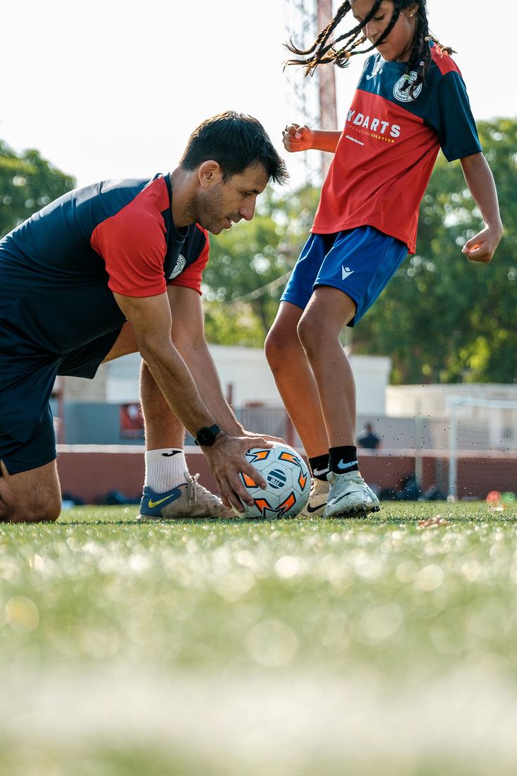 Mariano coloca el balón para el trabajo técnico de una jugadora